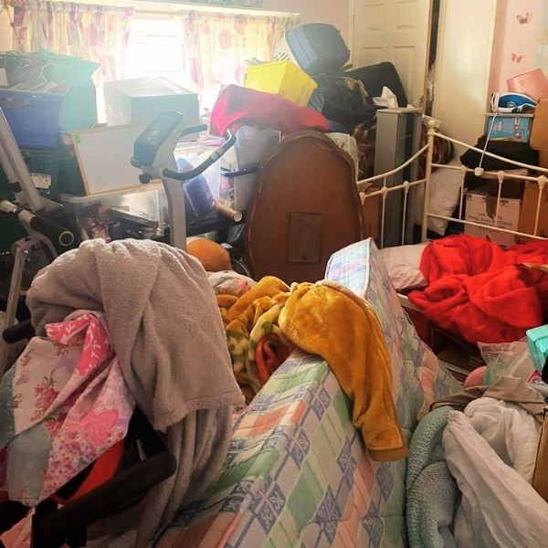 Cluttered room filled with furniture, bedding and household items before a Morris Movers house clearance in Thanet.